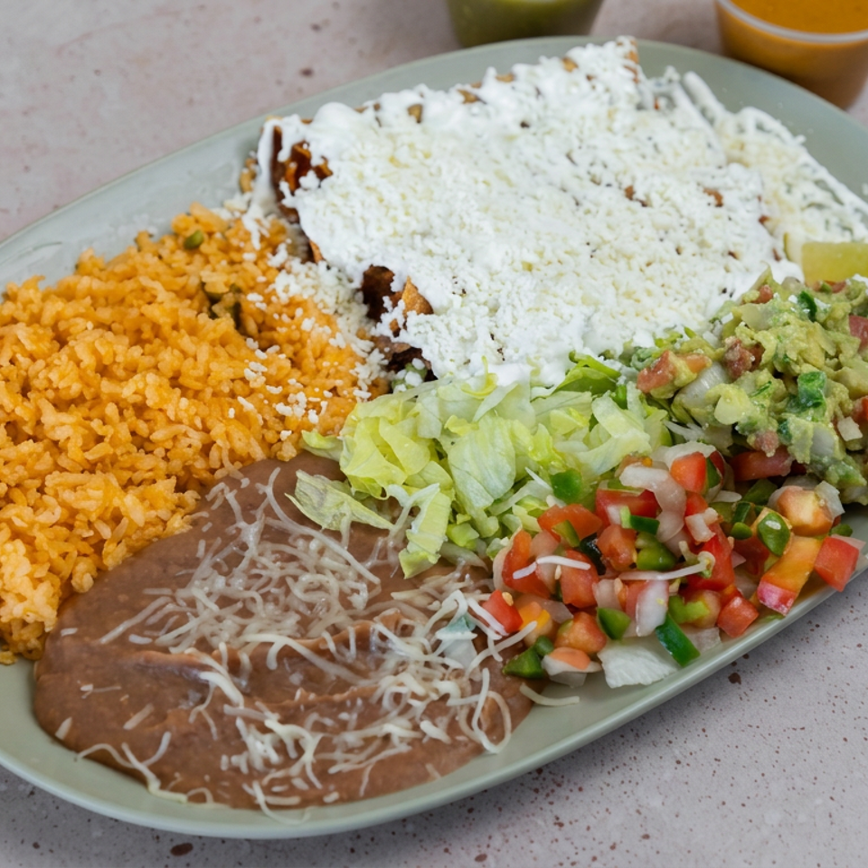 Mexican platter with rice, beans, cheese-covered entrée, lettuce, guacamole, pico de gallo, lime, and salsa.